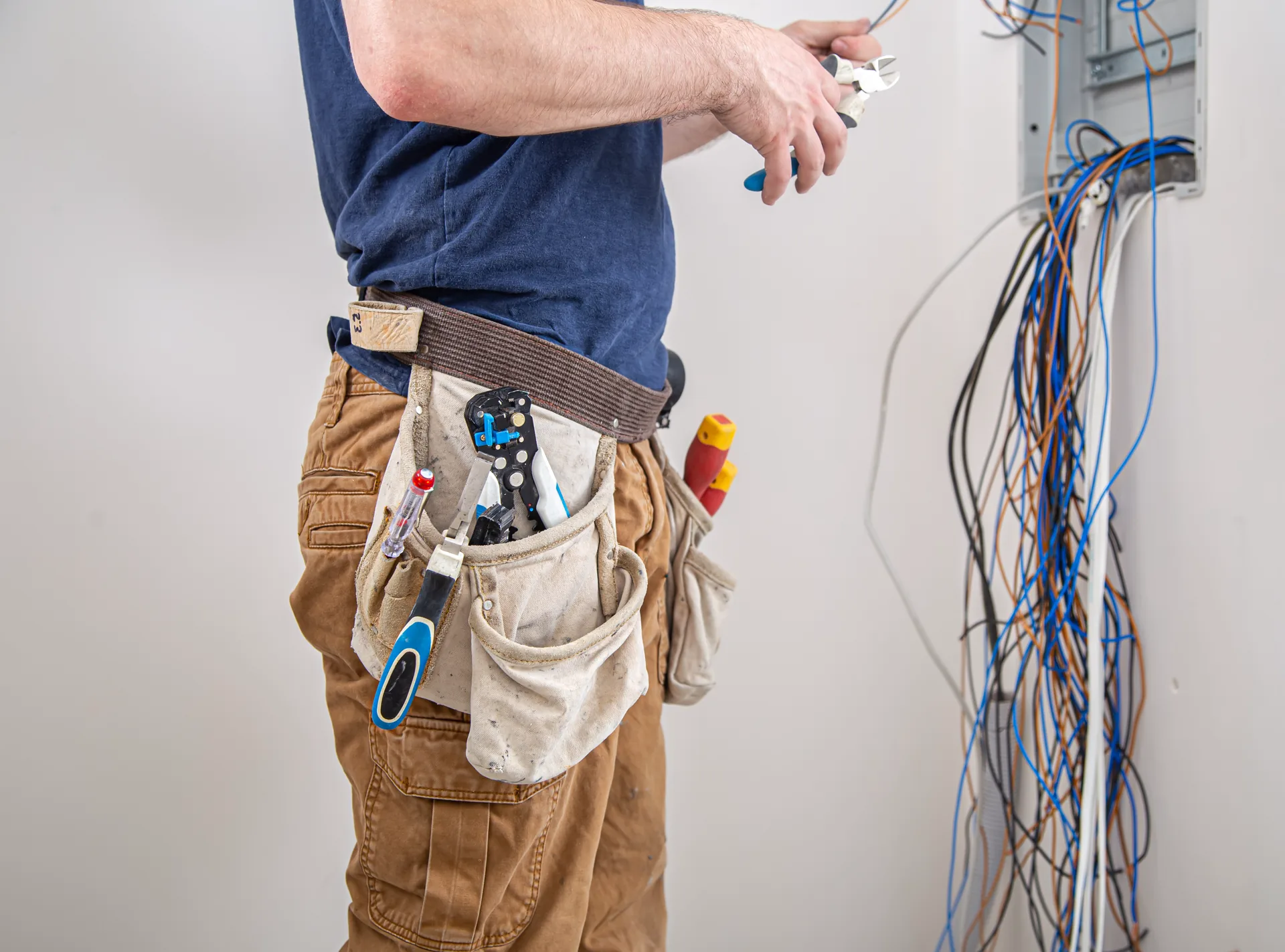 Elettricista professionista al lavoro su quadro e cavi